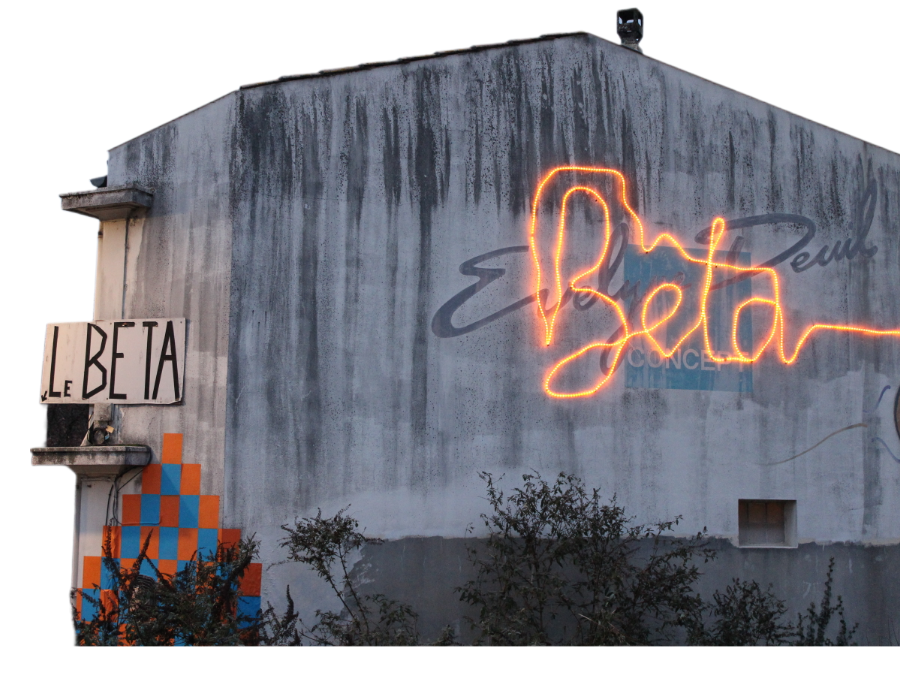 The Beta storefront. A garland of yellow lights spelling out “Bêta” on an old storefront, with a sign reading “Le Bêta”, also handcrafted.